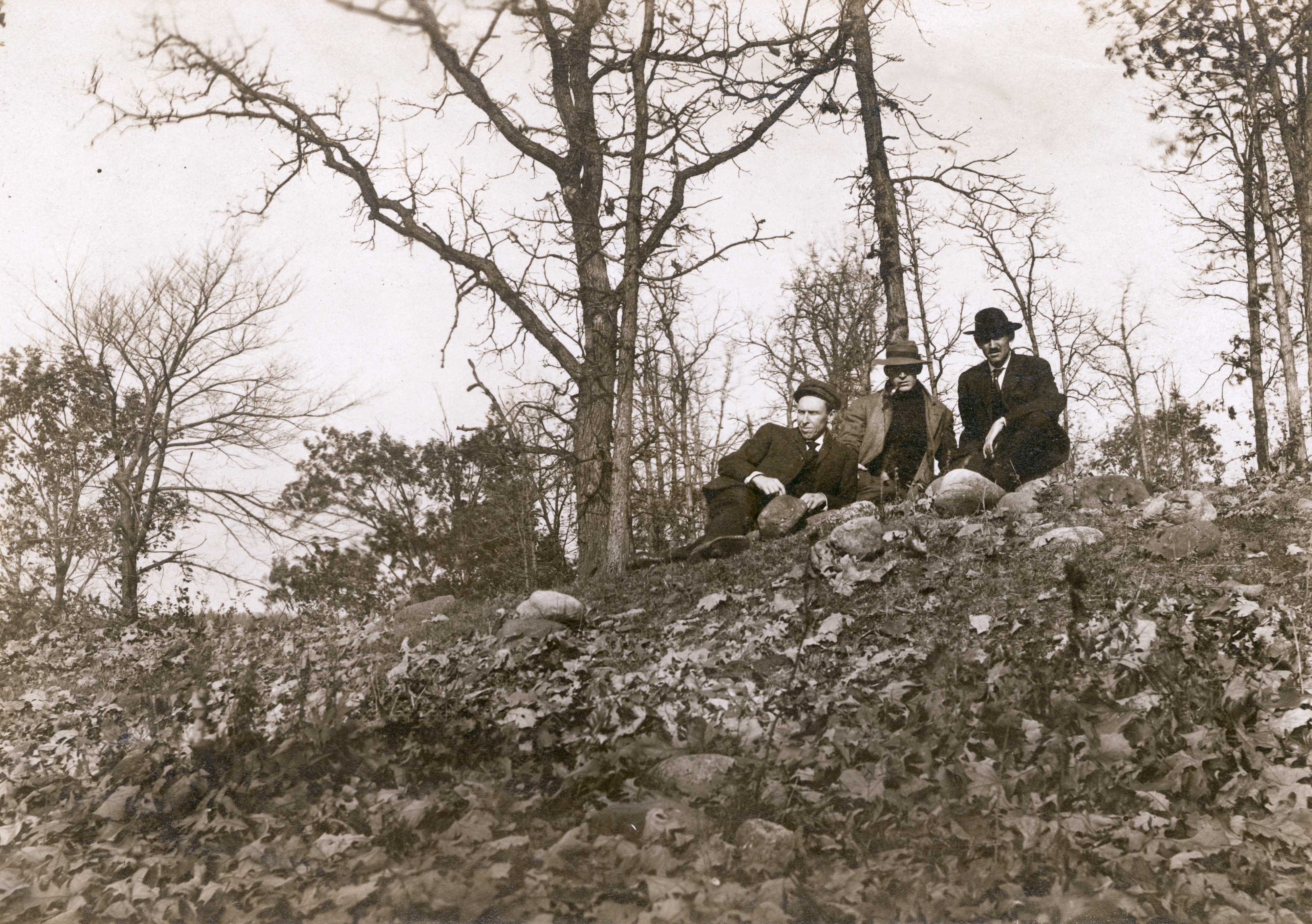 Reverend F.M. Gilmore, Professor W.E. Leonard, and Charles Brown relax on a burial mound on Fox Bluff near Lake Mendota.